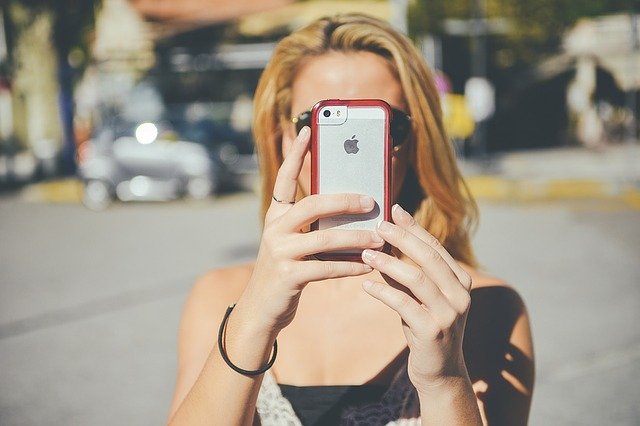 Mladá žena s mobilom, iPhone.jpg